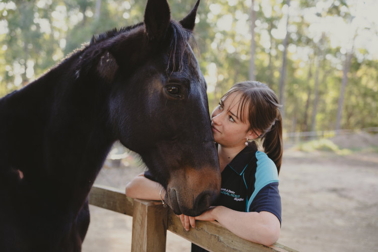 A young lady posing with a horse at Caspain Herd, equine facilitated learning centre